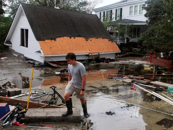 Resident Joseph Eudi looks at flood debris and storm damage from Hurricane Florence at a home on East Front Street in New Bern, N.C., Sept. 15, 2018.  (Gray Whitley / Sun Journal via AP)